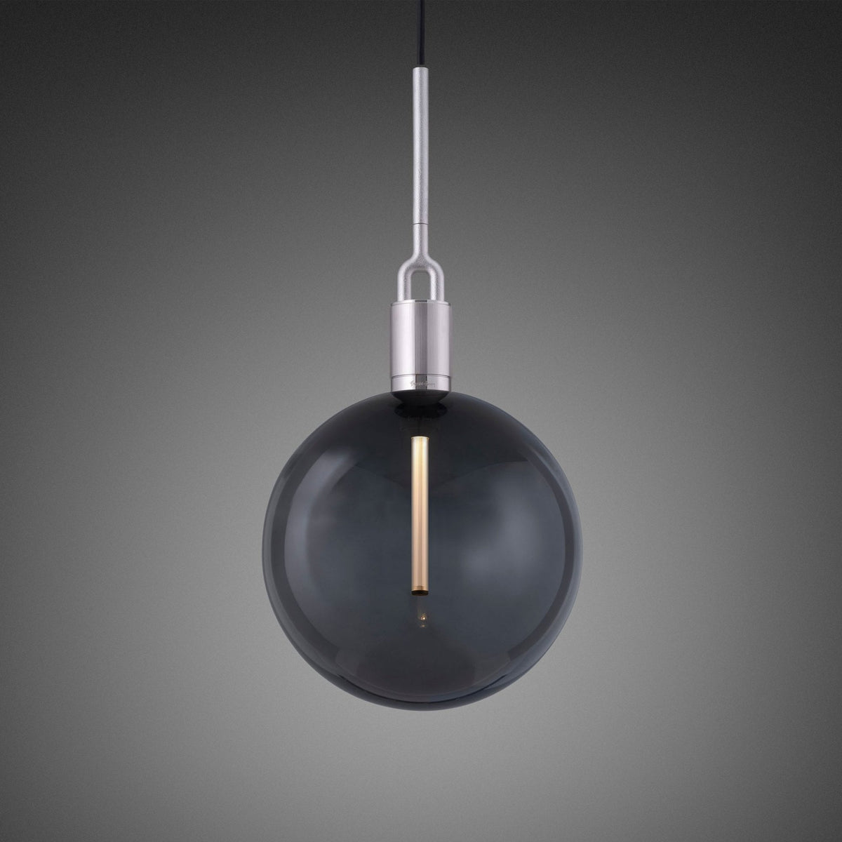 A modern pendant light with a smoked glass globe and a brushed metal fixture, hanging against a grey background.