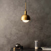 Forked Single Shade Pendant in a Brass Finish with Medium Opal Globe