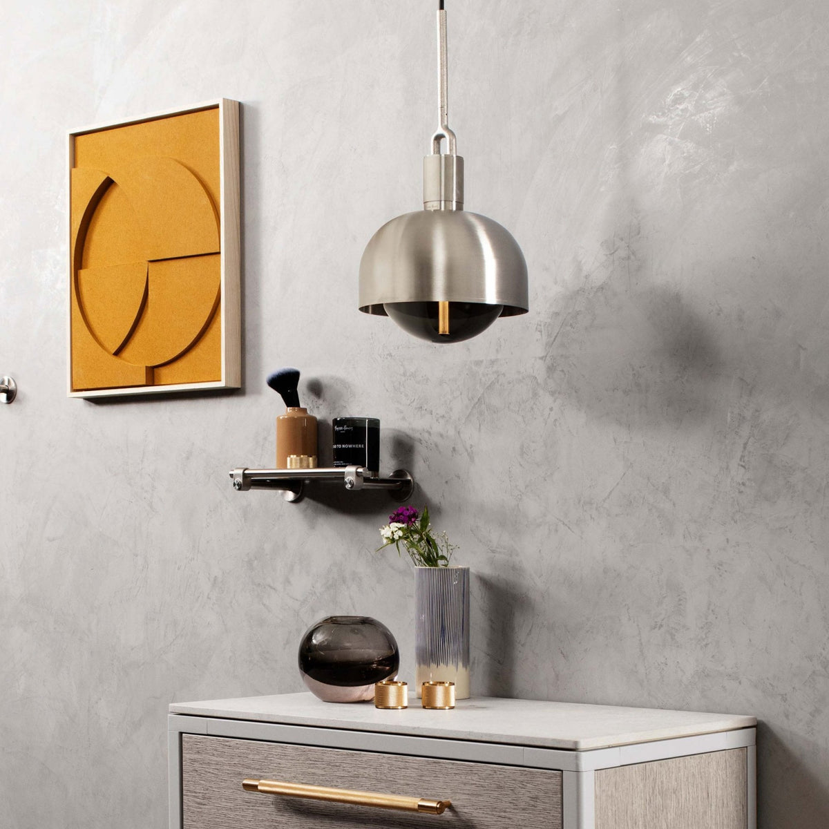 Modern room with a gray wall, a yellow abstract art piece, and a brushed nickel pendant light.