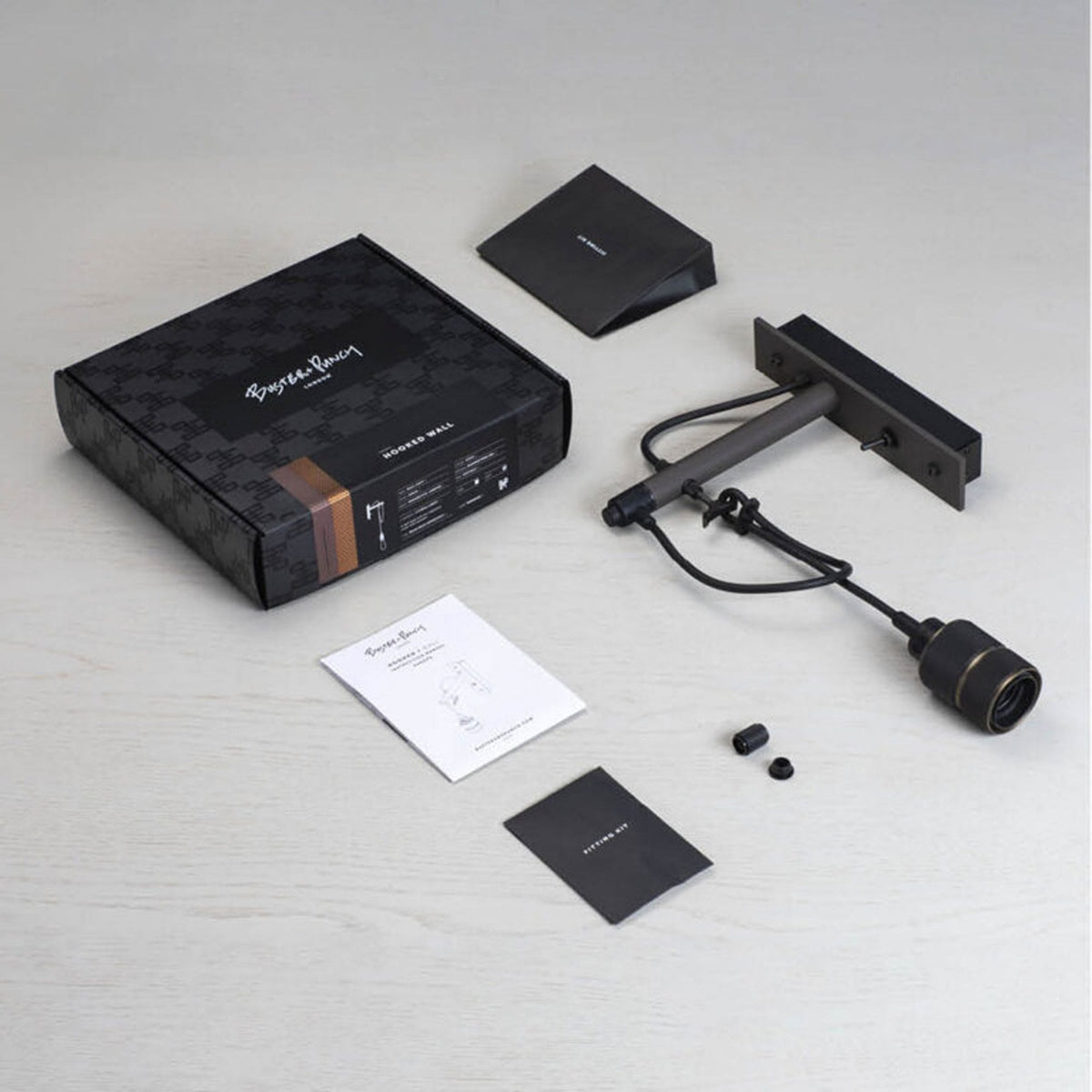 Buster + Punch Hooked Wall light kit with black box, instructions, and fitting kit on a white surface.