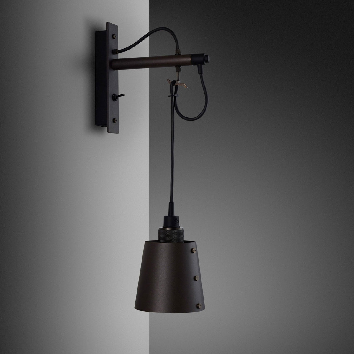 A dark bronze wall-mounted light fixture with an adjustable arm and a conical shade.