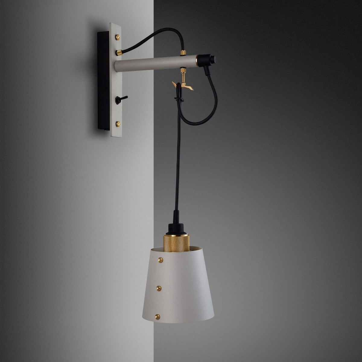 A modern wall-mounted lamp with a grey arm, black cord, and a conical grey shade with gold accents. 