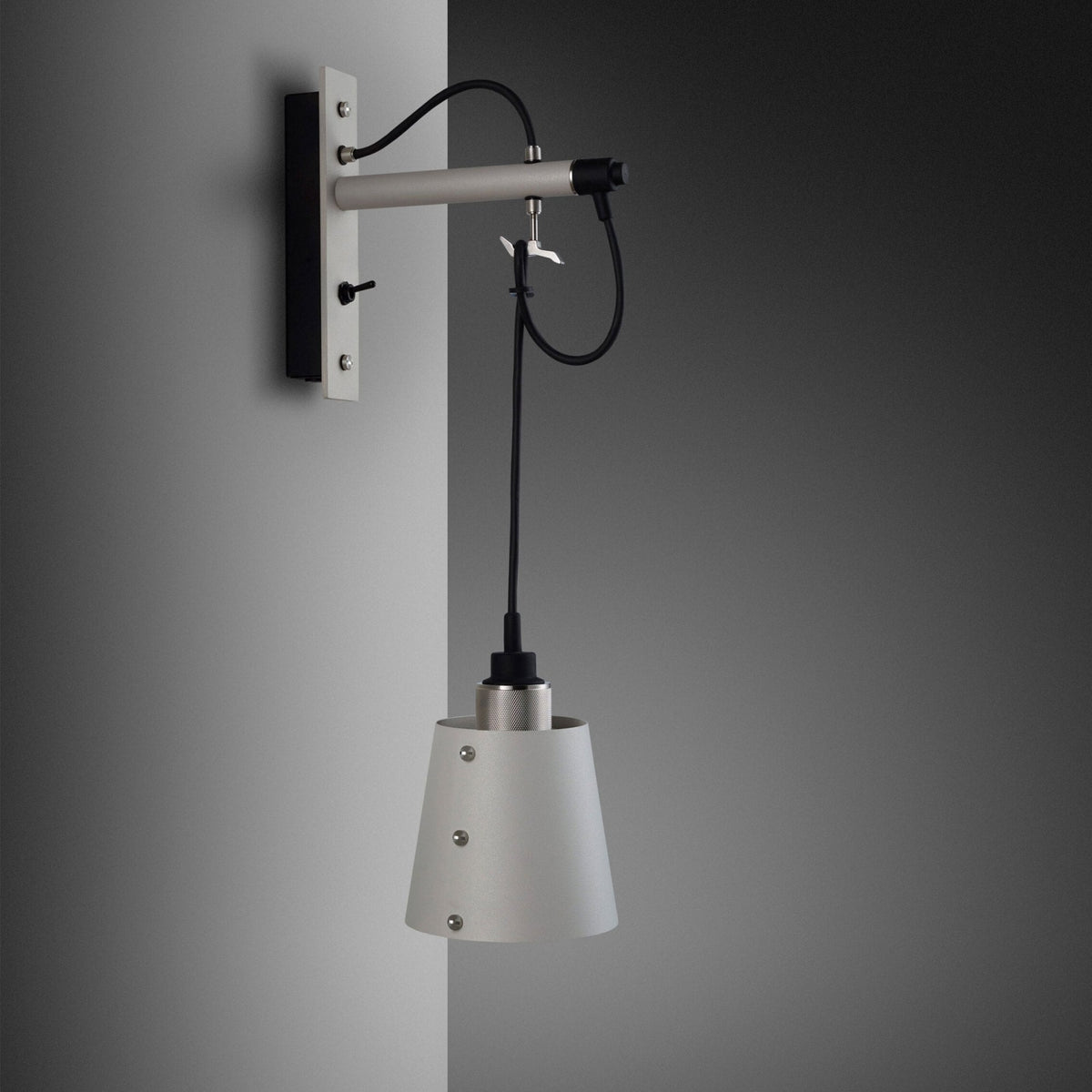 Modern wall-mounted lamp with a grey conical shade and exposed black wiring.
