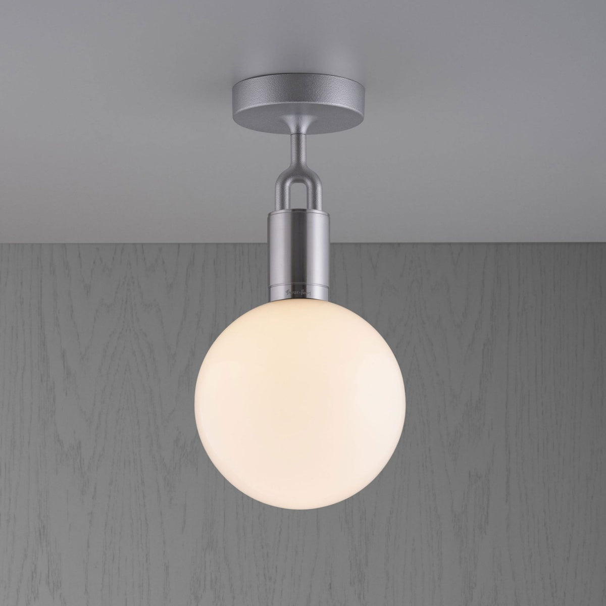 A modern ceiling light with a frosted spherical shade and a brushed silver base.