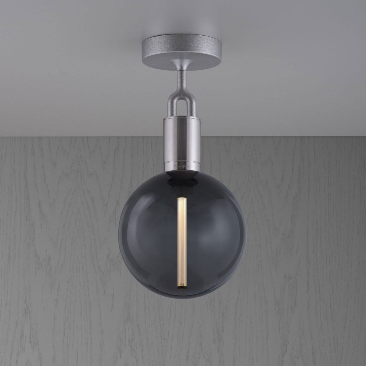 A modern ceiling light with a round, smoked glass bulb and a brushed metal fixture.