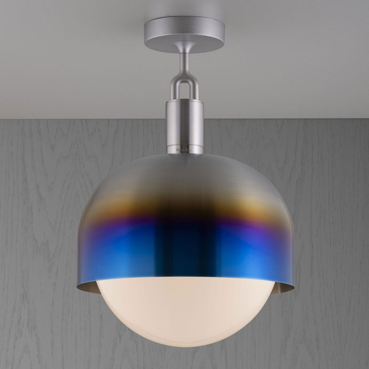 A ceiling light with a brushed metal dome shade that transitions from silver to blue and purple, with a white globe diffuser.