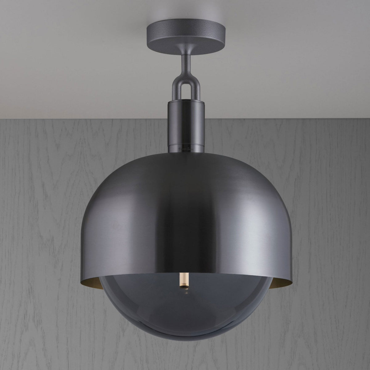 Modern ceiling light with a dark metal dome shade and a clear glass globe enclosing the bulb.
