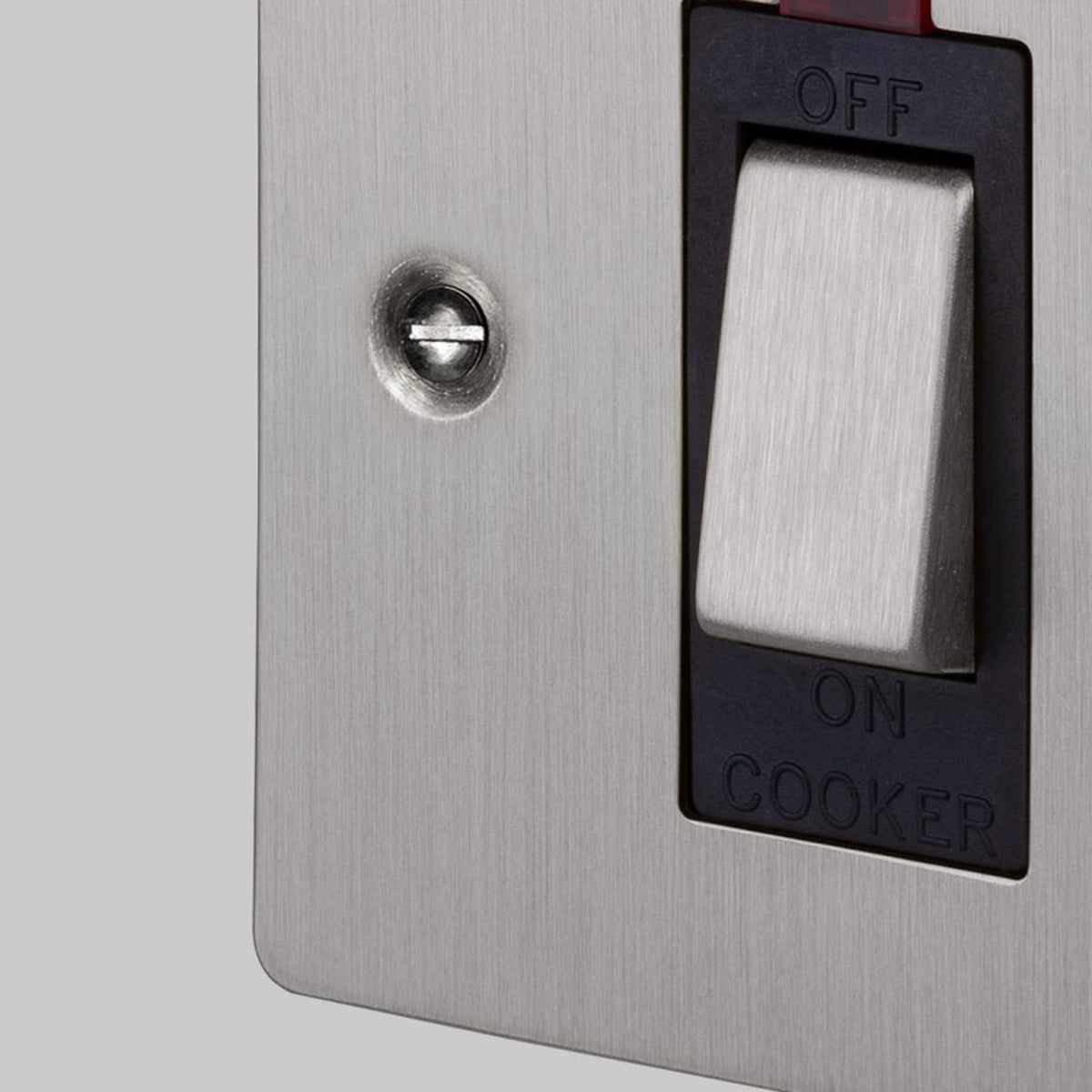 Close-up of a brushed metal cooker switch with a red indicator light and ON/OFF labels.