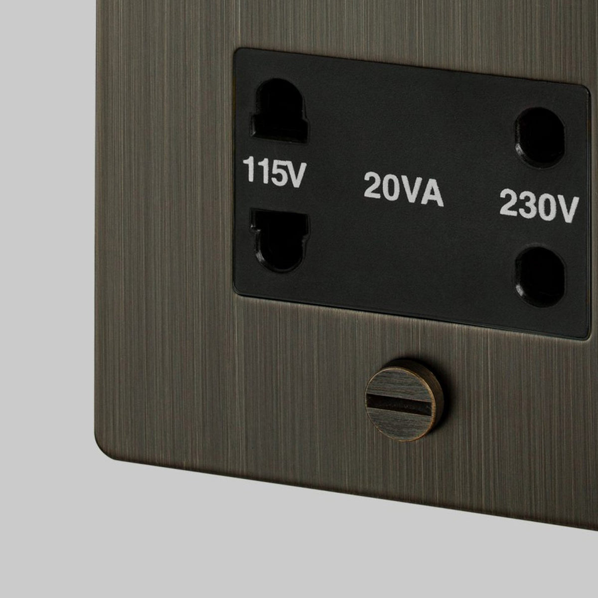 Close-up of a brushed bronze shaver socket with 115V and 230V outlets.