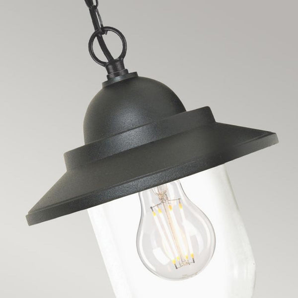A close-up view of the black metal hanging lantern, highlighting the clear glass shade.