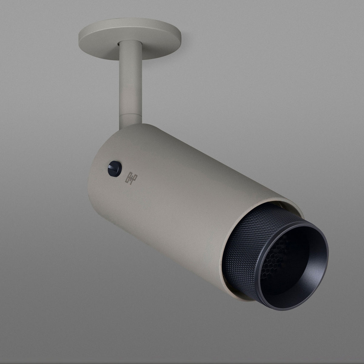 A beige cylindrical ceiling light fixture with a black textured interior and a small black button on its side.