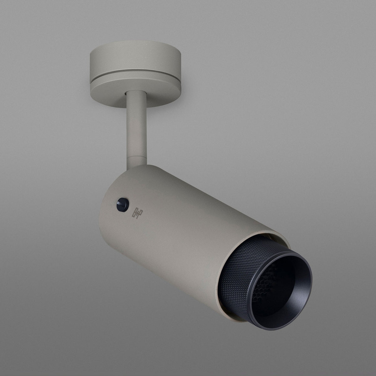 A light grey cylindrical ceiling-mounted spotlight with a textured black inner rim, angled downwards.