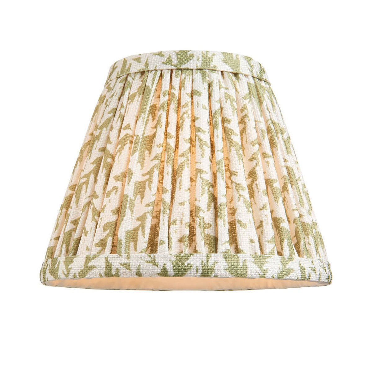 A pleated lamp shade with a green and white abstract pattern, lit from within.