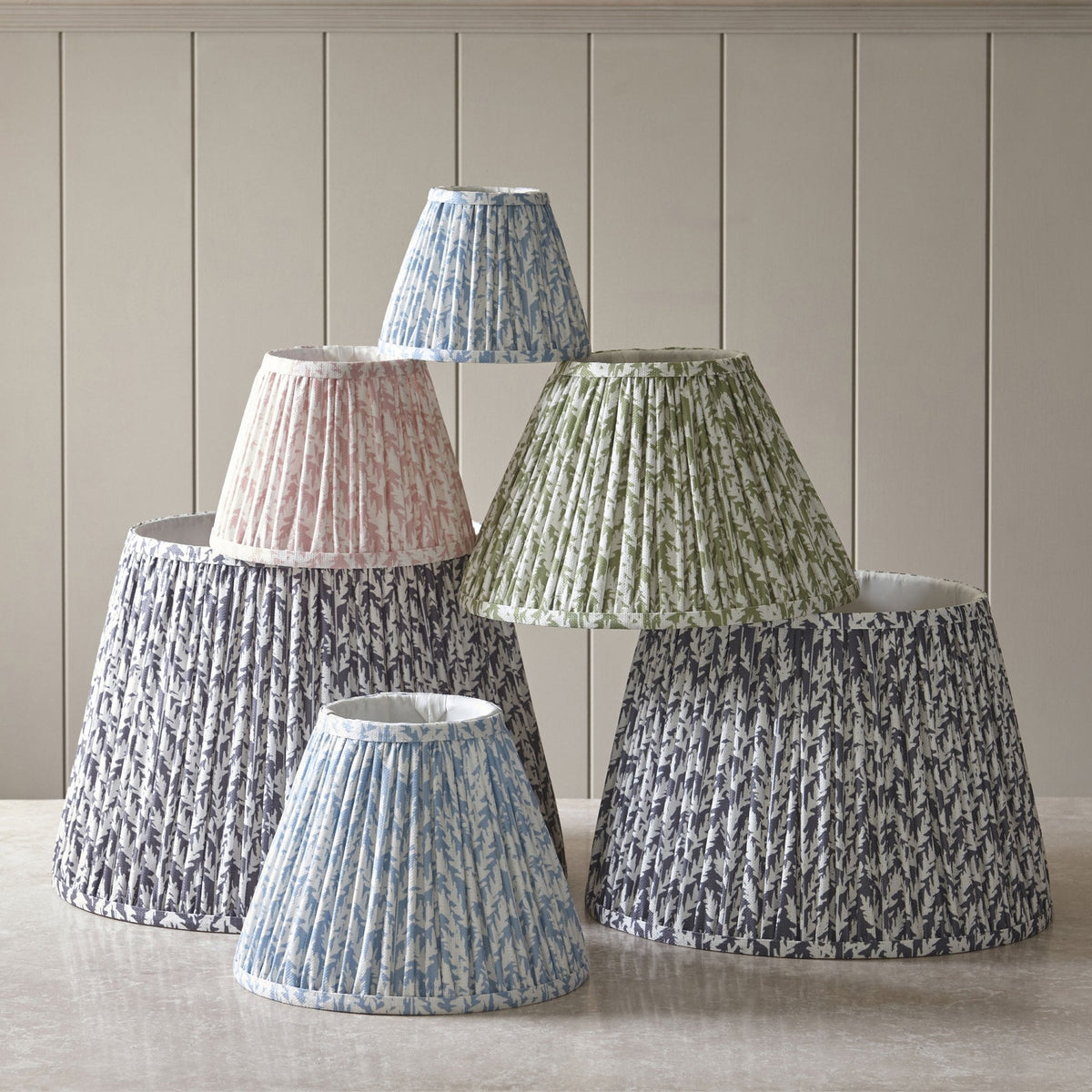 A collection of pleated lamp shades in various sizes and colours.