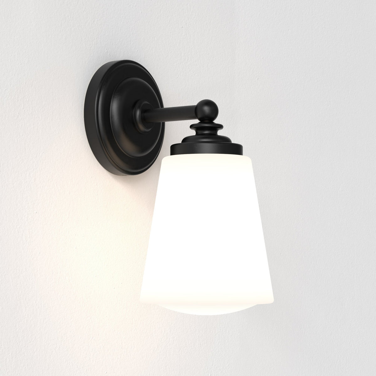 Black wall sconce with a white conical shade