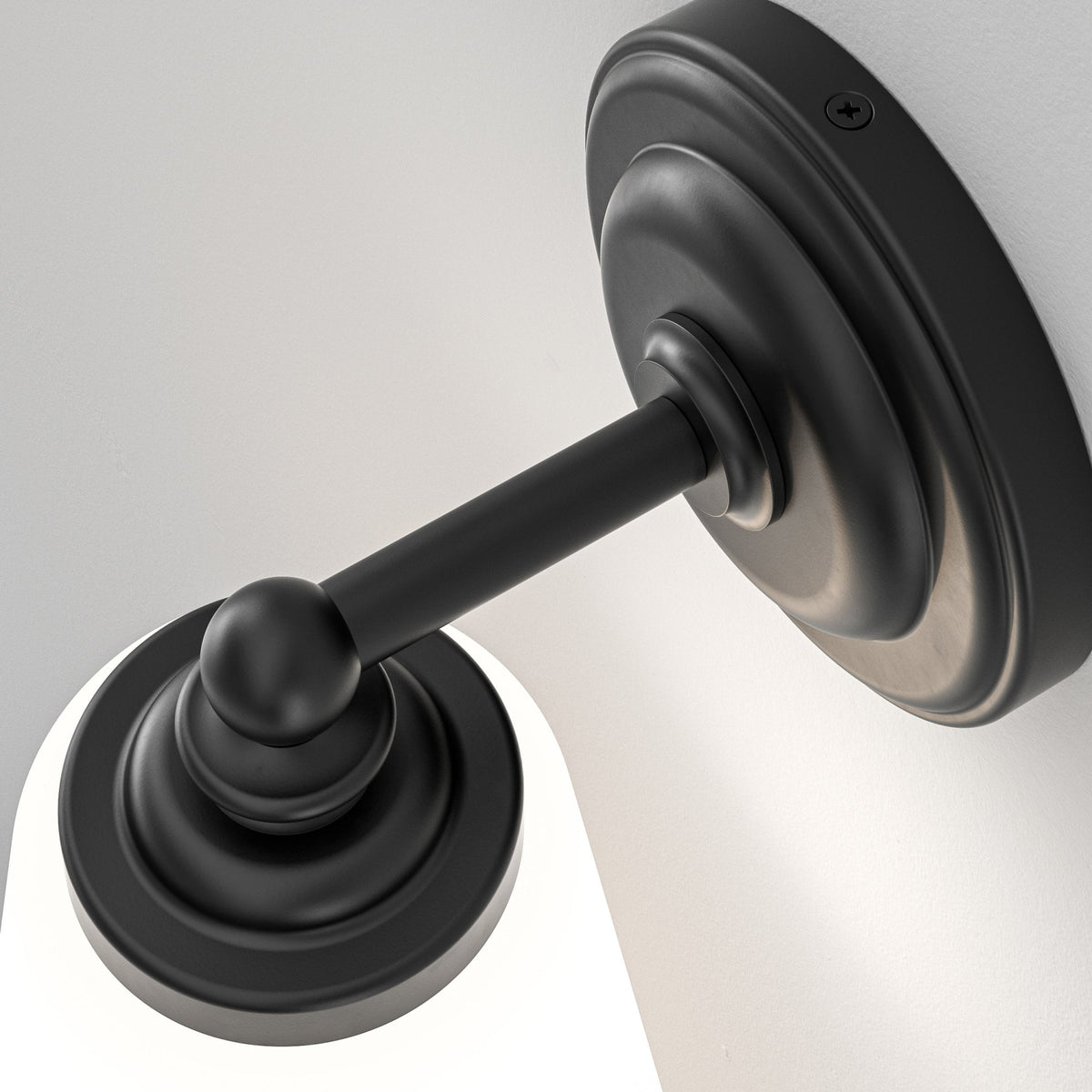 Black wall sconce with a white cylindrical shade