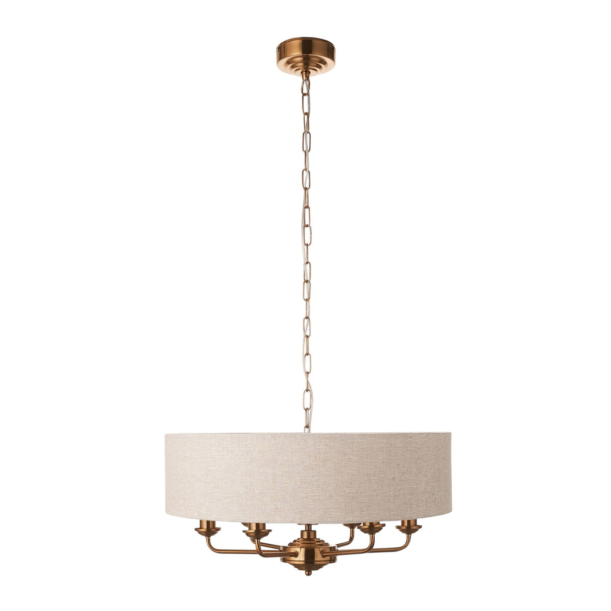 A brass chandelier with a large, round, light-colored fabric shade hangs from a ceiling on a white background.