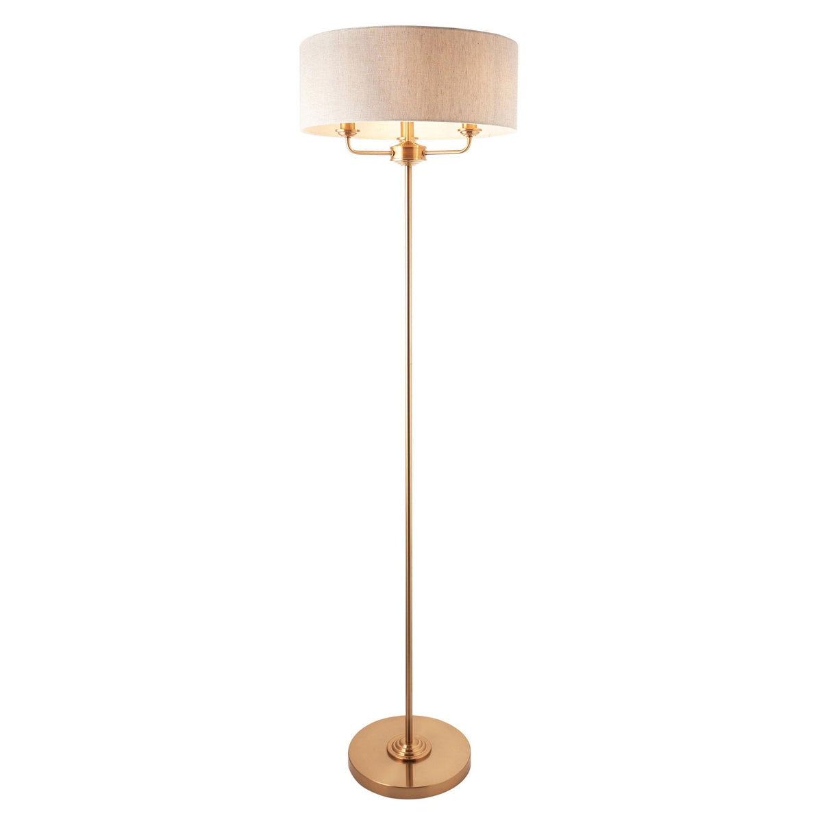 A tall brass floor lamp with a cream drum shade on a white background.