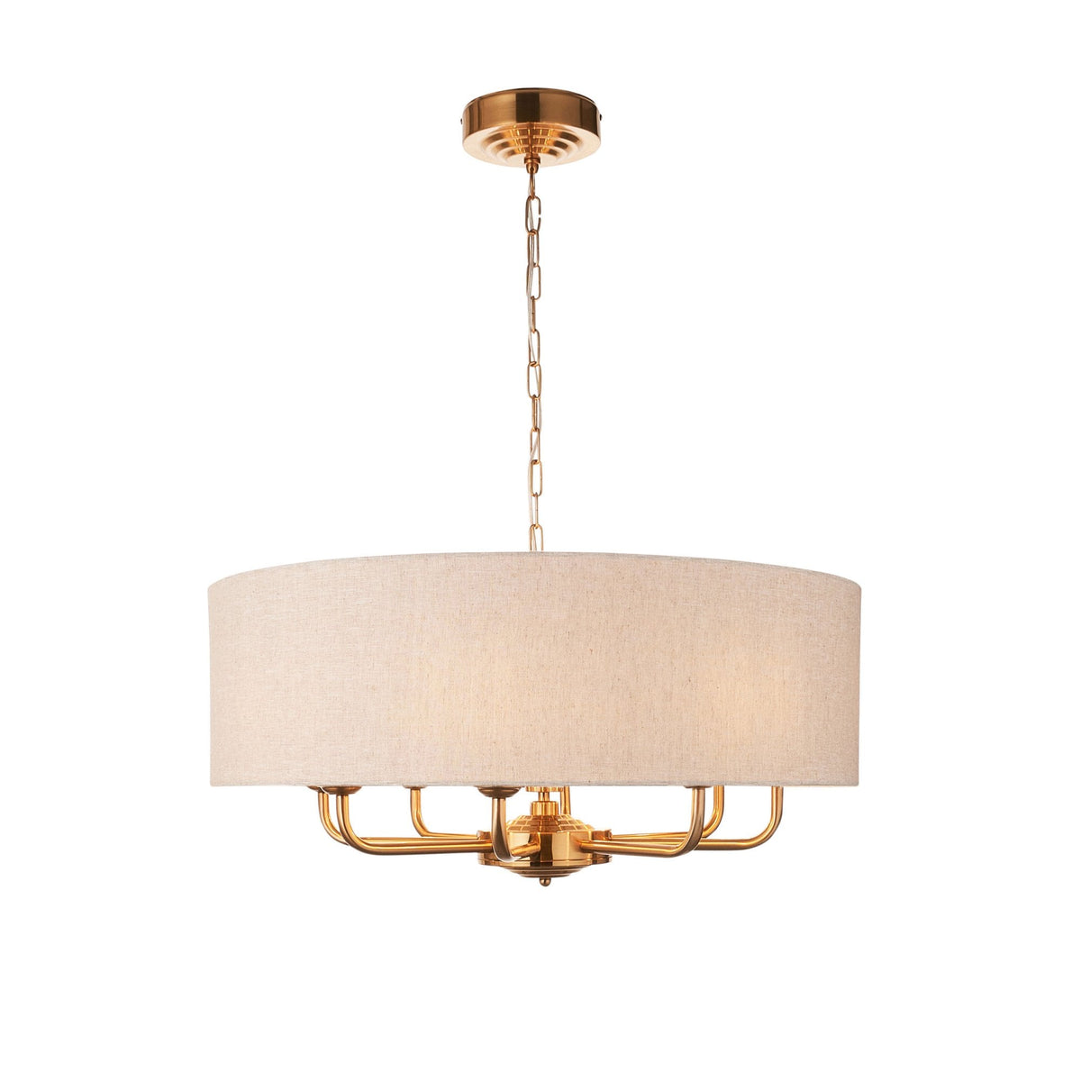 A gold chandelier with a light fabric drum shade on a white background.