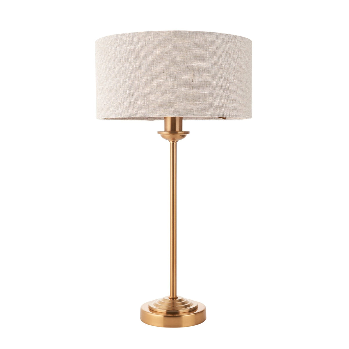 A brass table lamp with a light linen drum shade on a white background.
