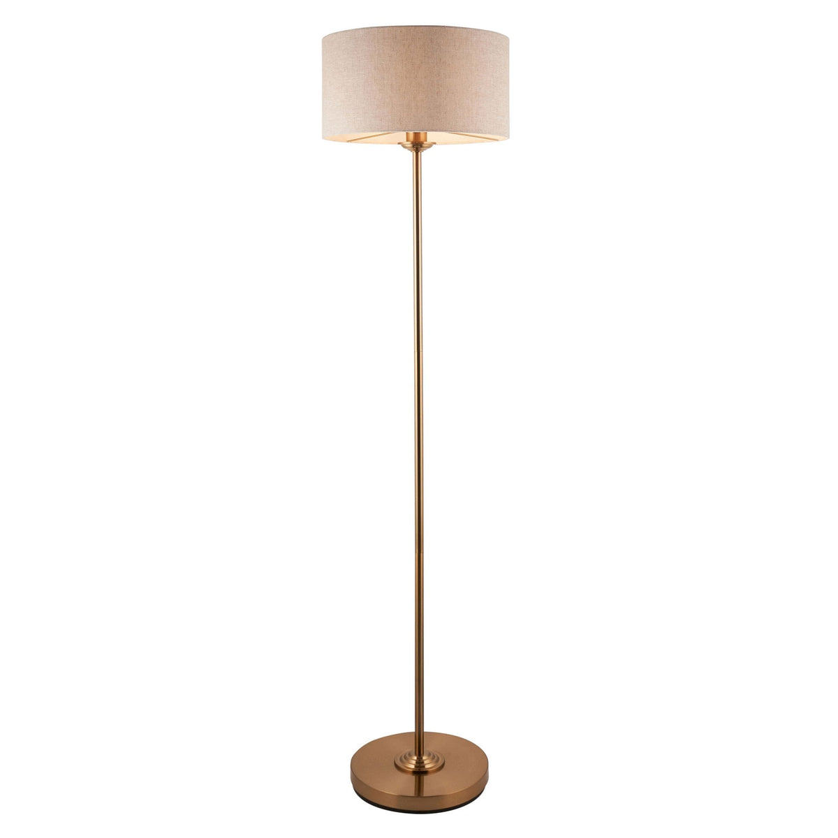 A tall, slender brass floor lamp with a light-colored drum shade on a white background.