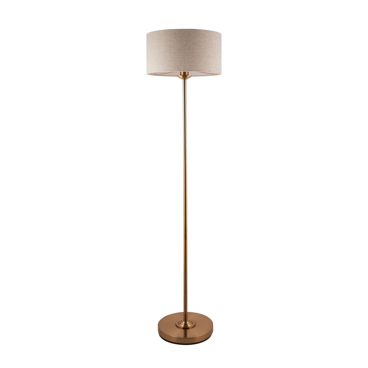 A tall, slender brass floor lamp with a light-colored drum shade on a white background.