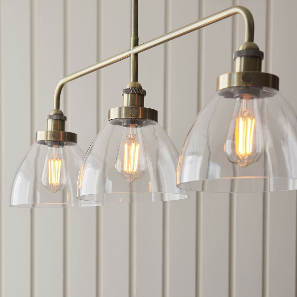Hansen Triple Light Linear Pendant in Antique Brass and Clear Glass Shades