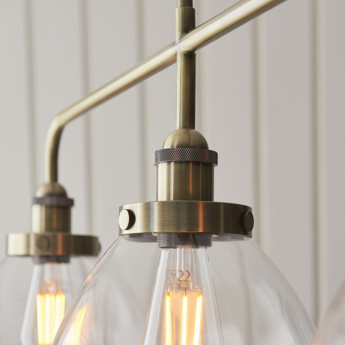 Hansen Triple Light Linear Pendant in Antique Brass and Clear Glass Shades