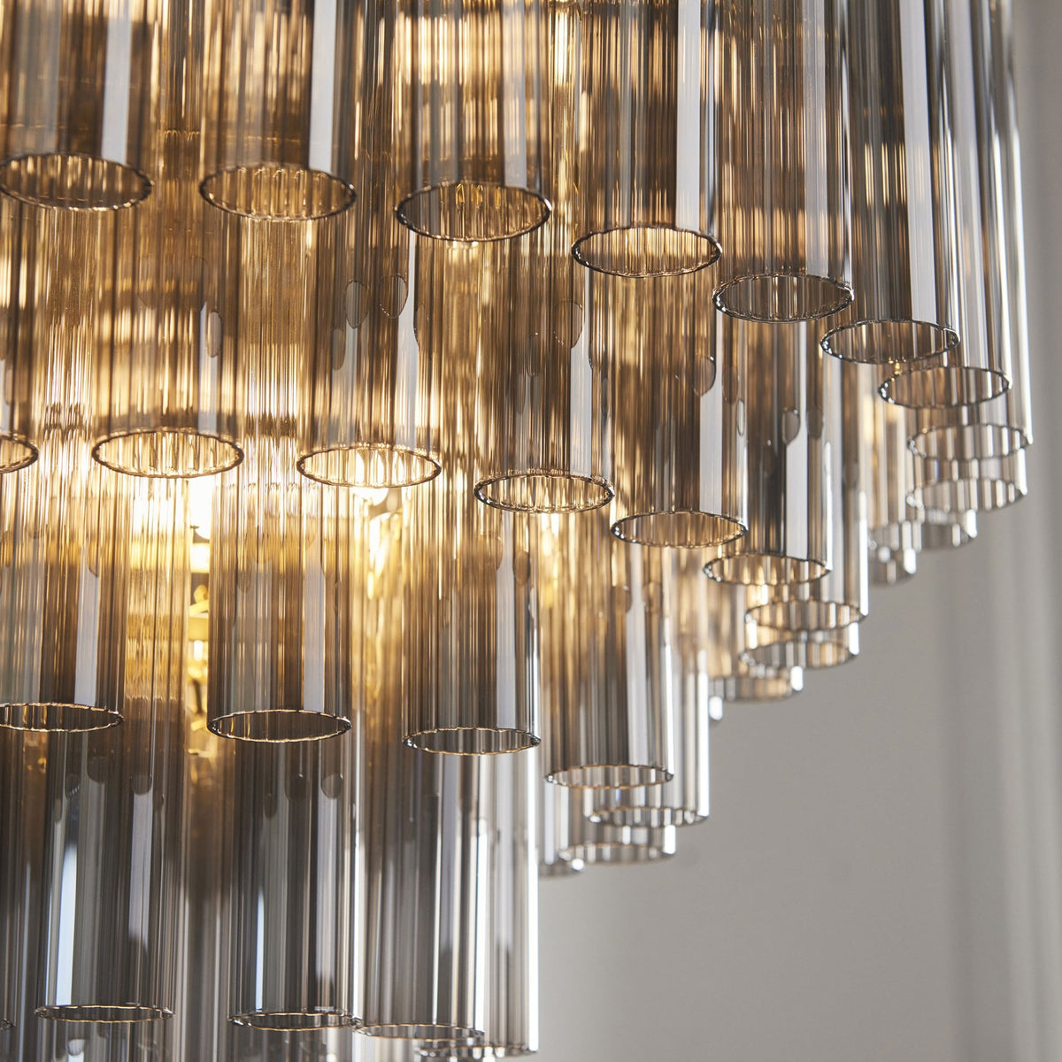 Toulouse Twelve Light Tiered Pendant in Brushed Gold with Ribbed Cylindrical Smokey Glass