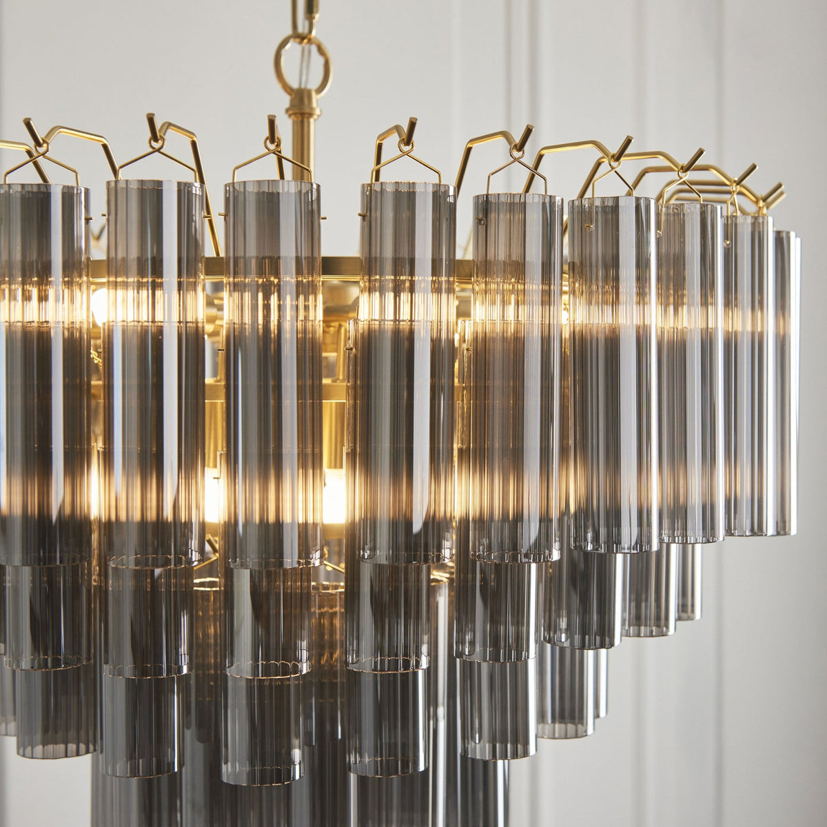 Toulouse Twelve Light Tiered Pendant in Brushed Gold with Ribbed Cylindrical Smokey Glass