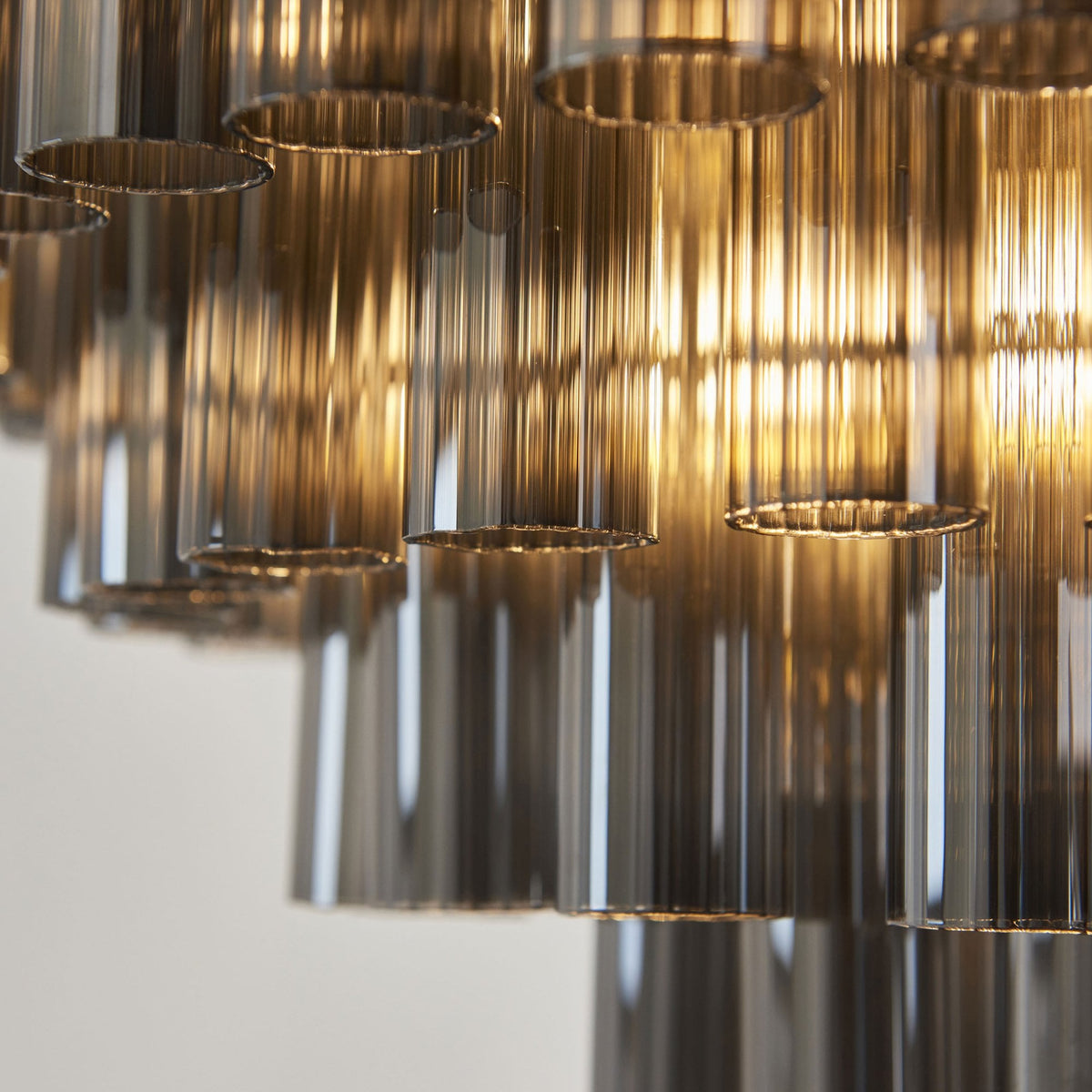 Toulouse Twelve Light Tiered Pendant in Brushed Gold with Ribbed Cylindrical Smokey Glass