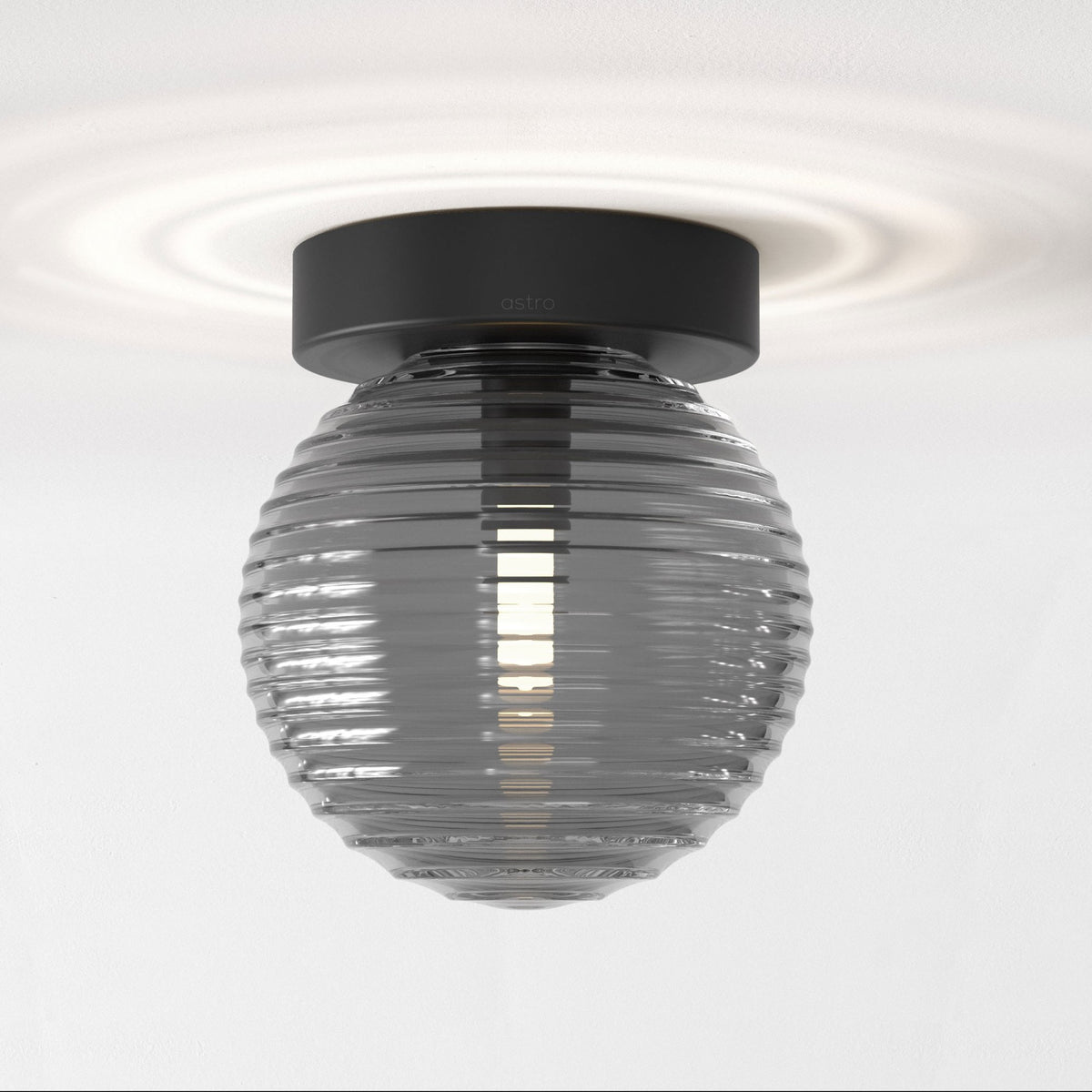 A black base with a ribbed, smokey-grey spherical light shade.