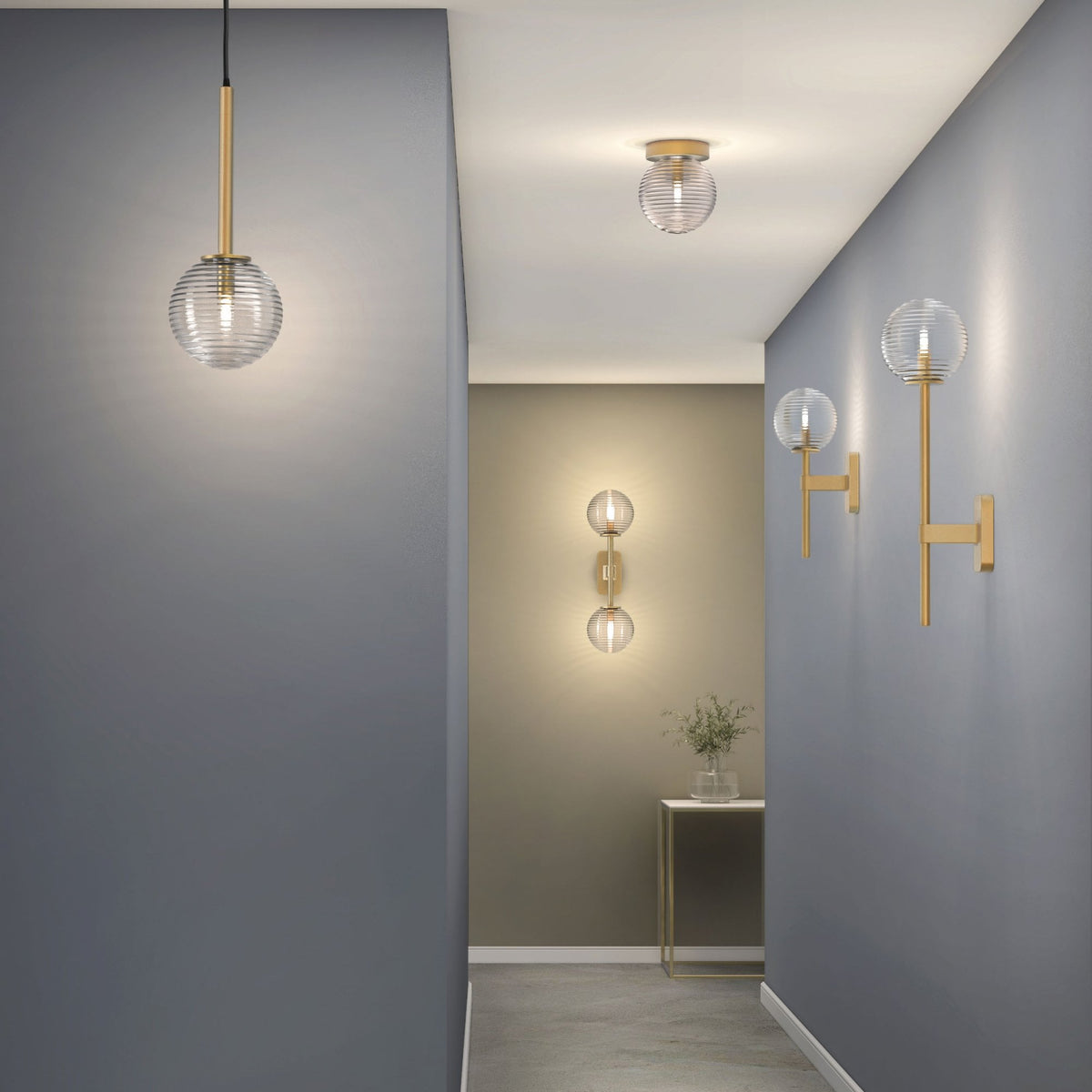 Hallway with pendant light, ceiling light, and wall lights, all with ribbed glass shades and brass accents