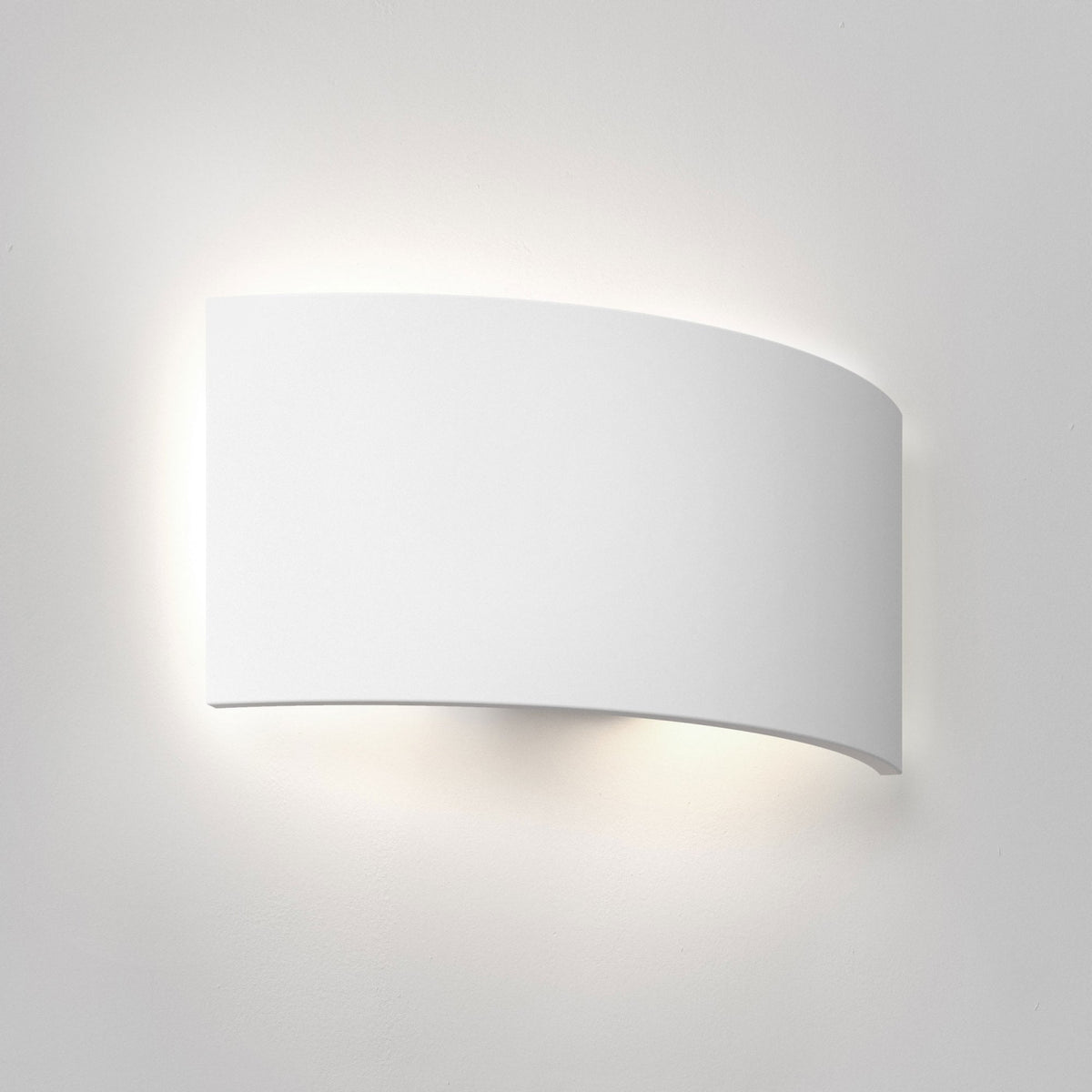 White curved wall light fixture illuminating a white wall