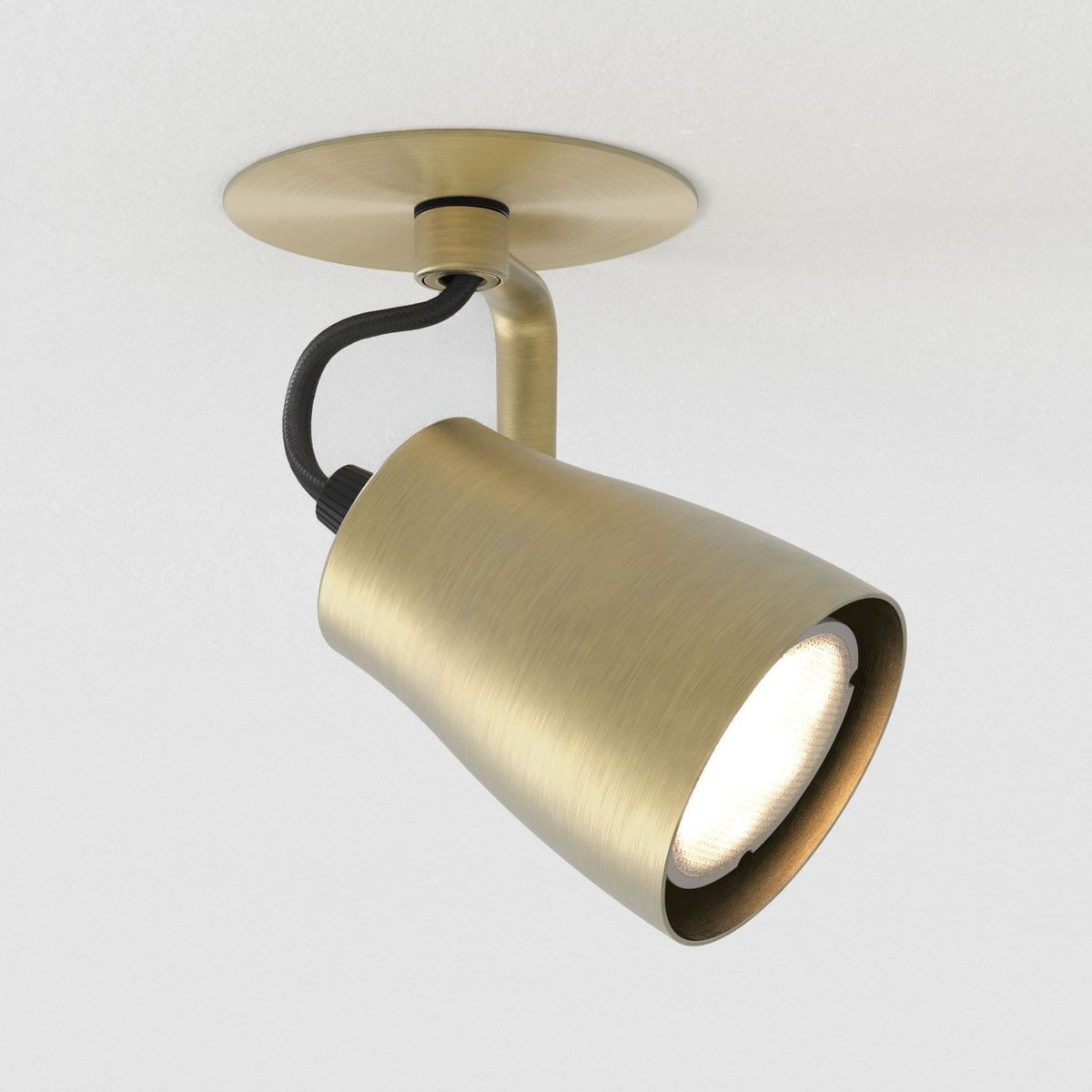 Brushed brass ceiling spotlight with a black braided cable