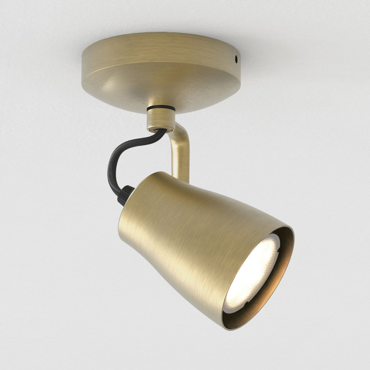 Brushed brass ceiling spotlight with a black braided cable