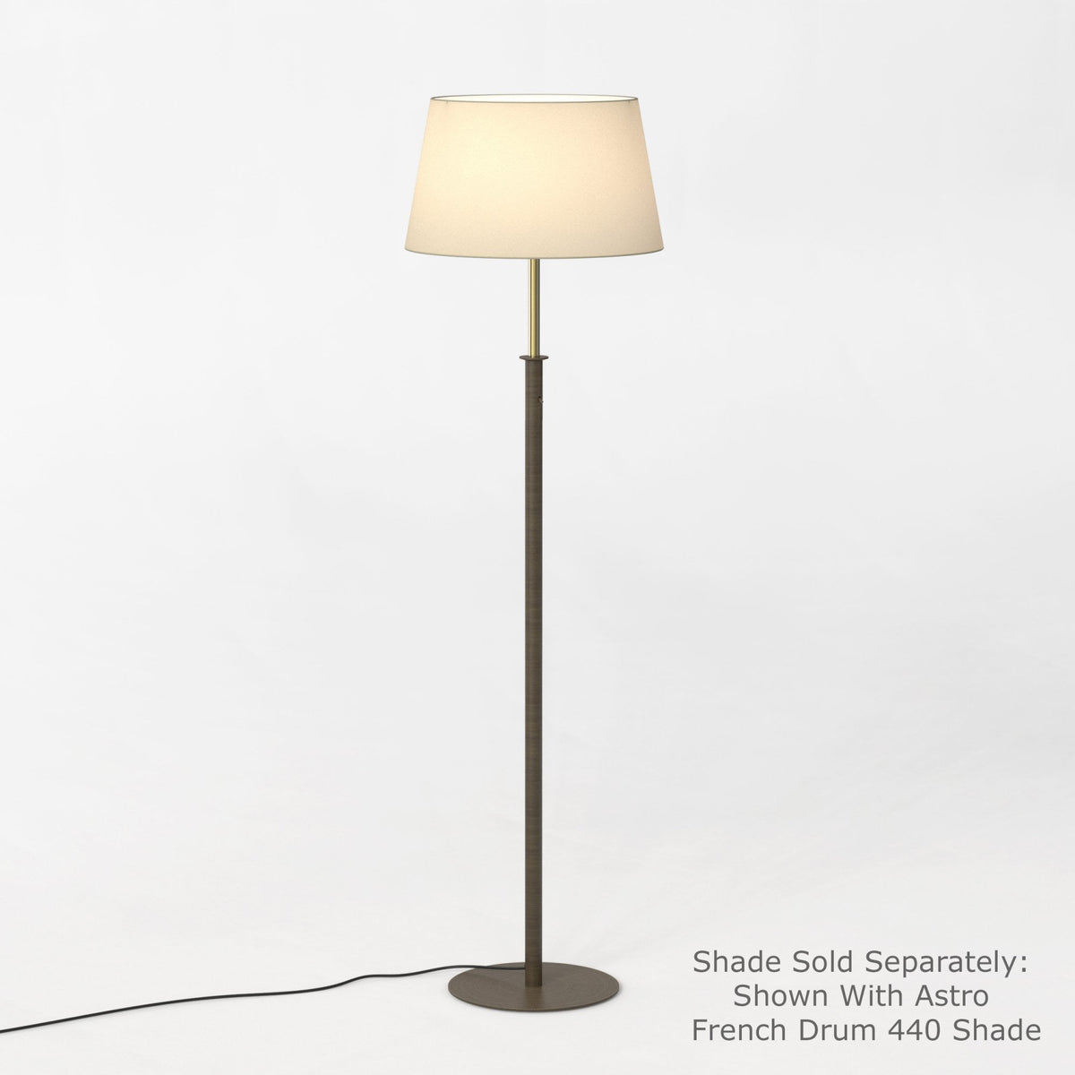 Floor lamp with a dark bronze base and stem, and a light-colored fabric drum shade