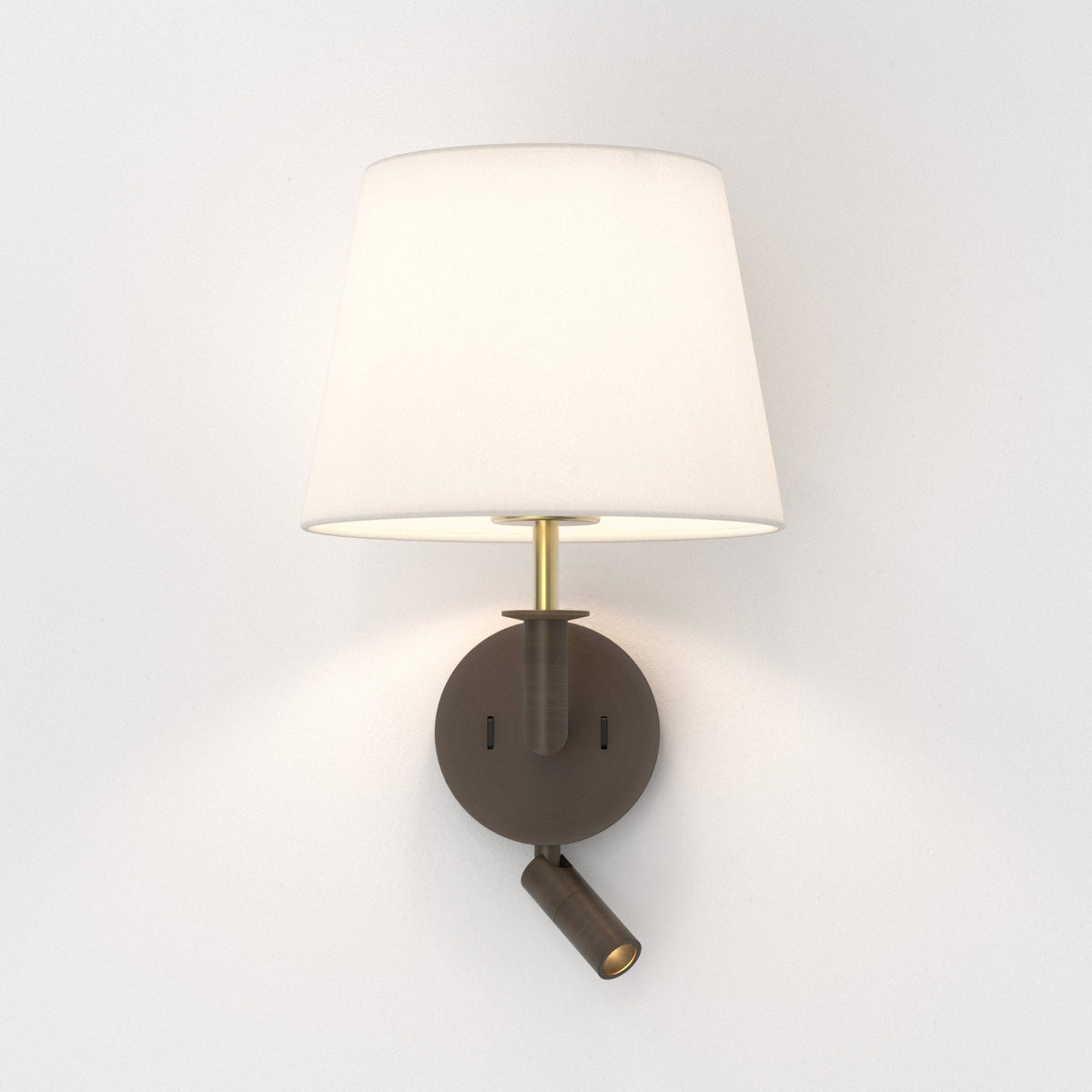 Wall mounted lamp with a white fabric shade and a bronze base, featuring an adjustable reading light