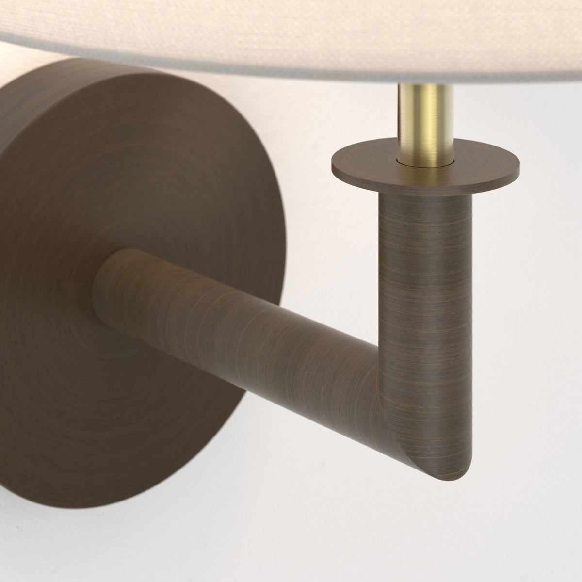 Close up of a bronze wall sconce with a white fabric shade