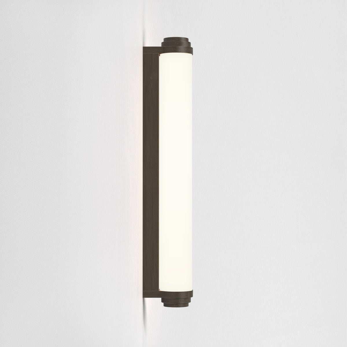 Vertical wall light with a dark bronze base and a cylindrical white glass shade