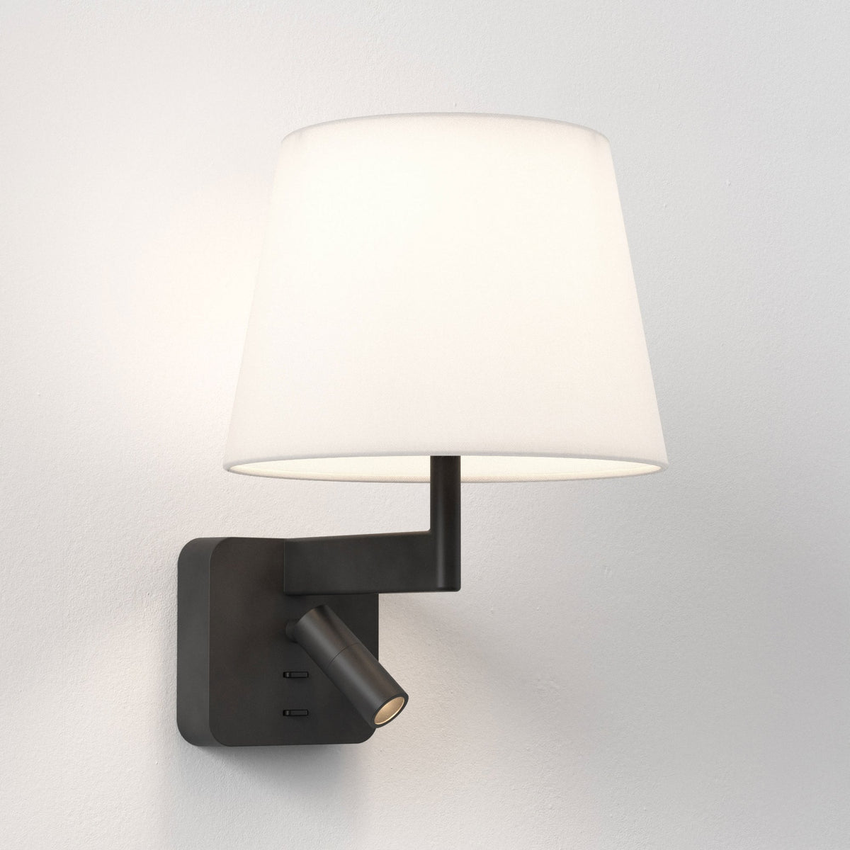 Wall-mounted lamp with a white fabric shade and a black adjustable spotlight