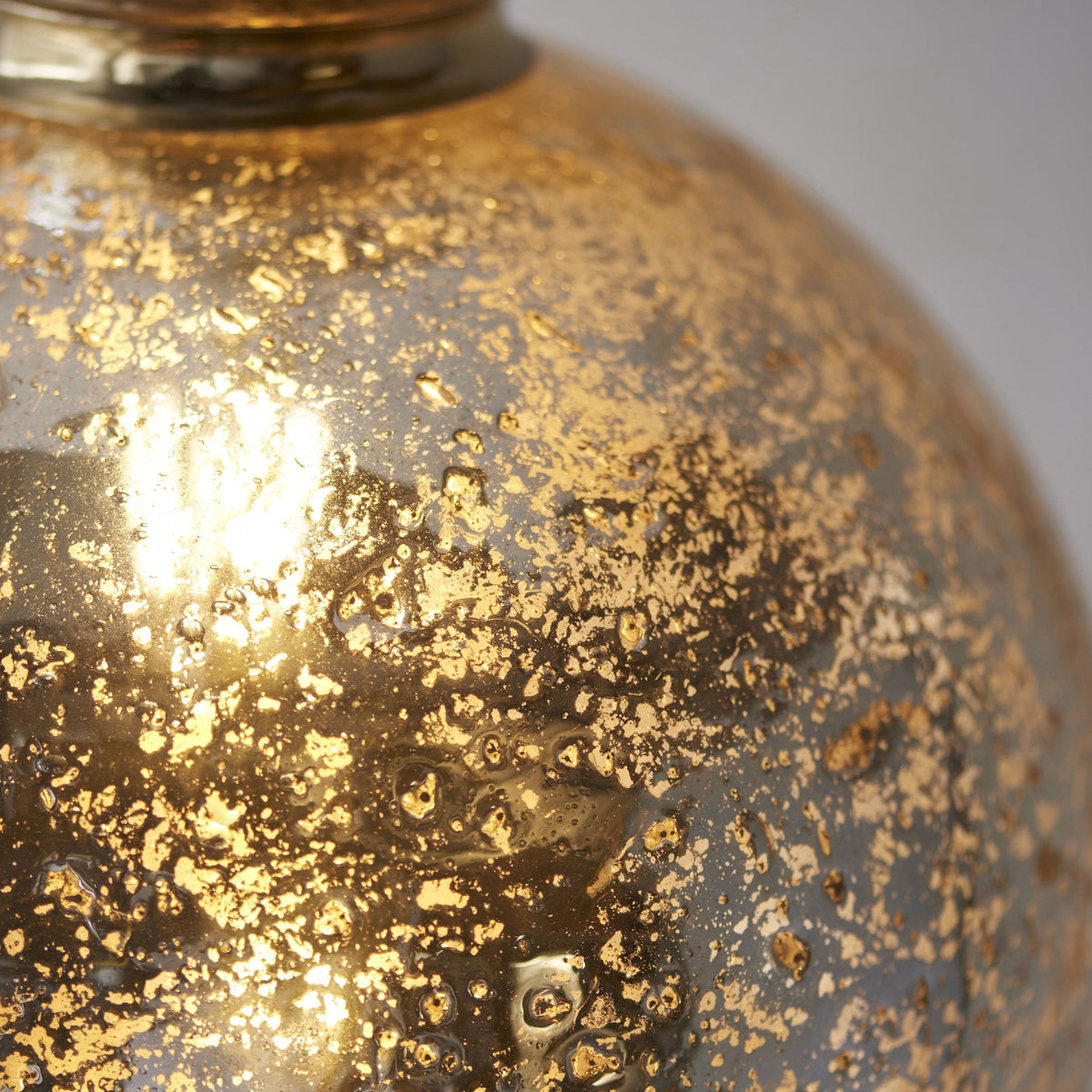 Close-up of a rustic, textured amber glass pendant light, showcasing its intricate, mottled surface.