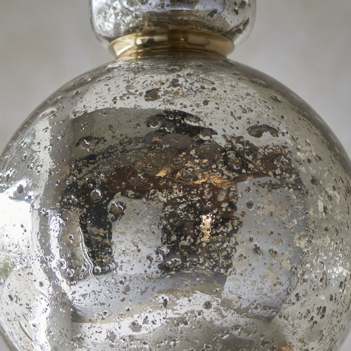 Close-up of a textured silver glass pendant light, revealing a subtle internal glow and intricate surface.