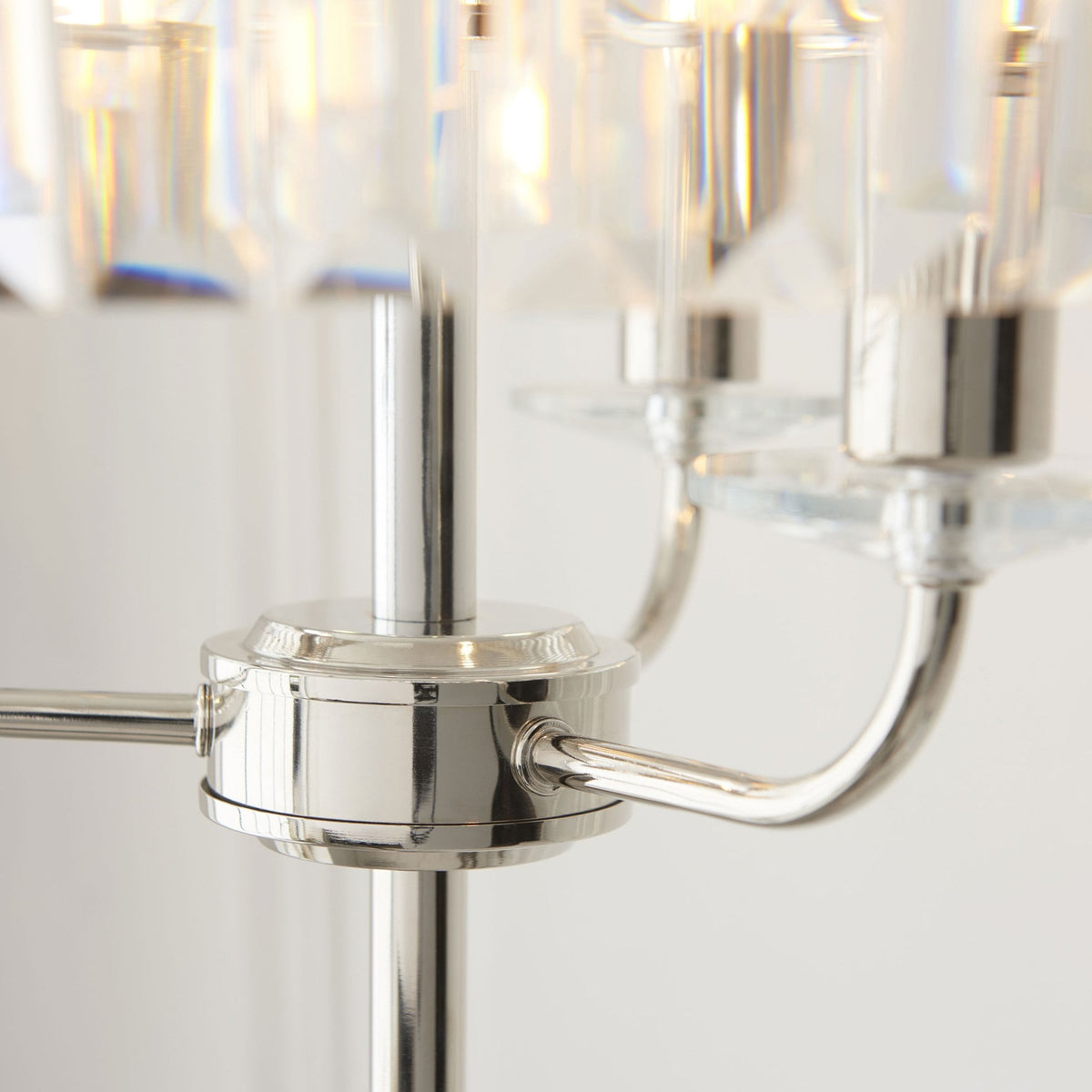 Gros plan sur la base en nickel brossé du lampadaire et le détail du support de l'abat-jour.