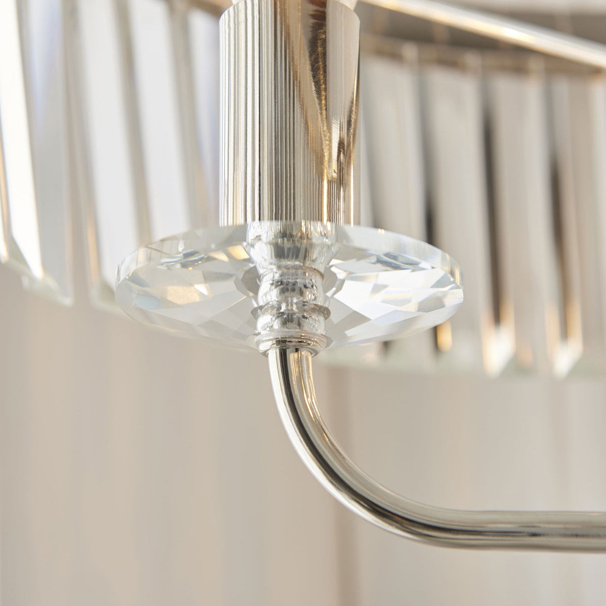 Détail rapproché d'une pièce de cristal facetée sur le bras de support du lampadaire en nickel.