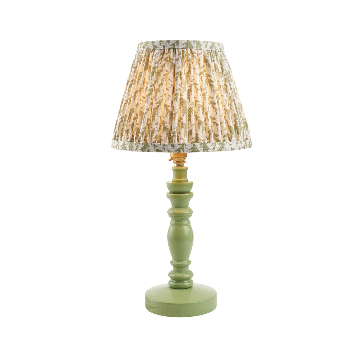 A table lamp with a green wooden base and a lit patterned fabric shade on a white background.