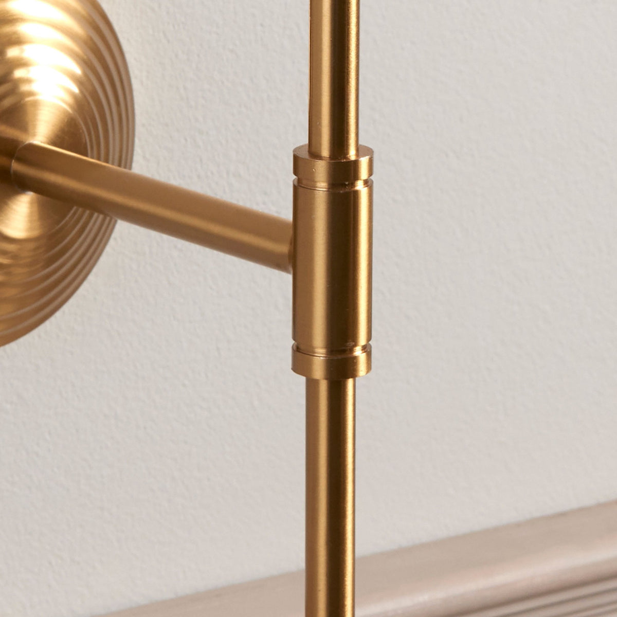 Close-up of the articulated joint on the brass arm of the wall light.