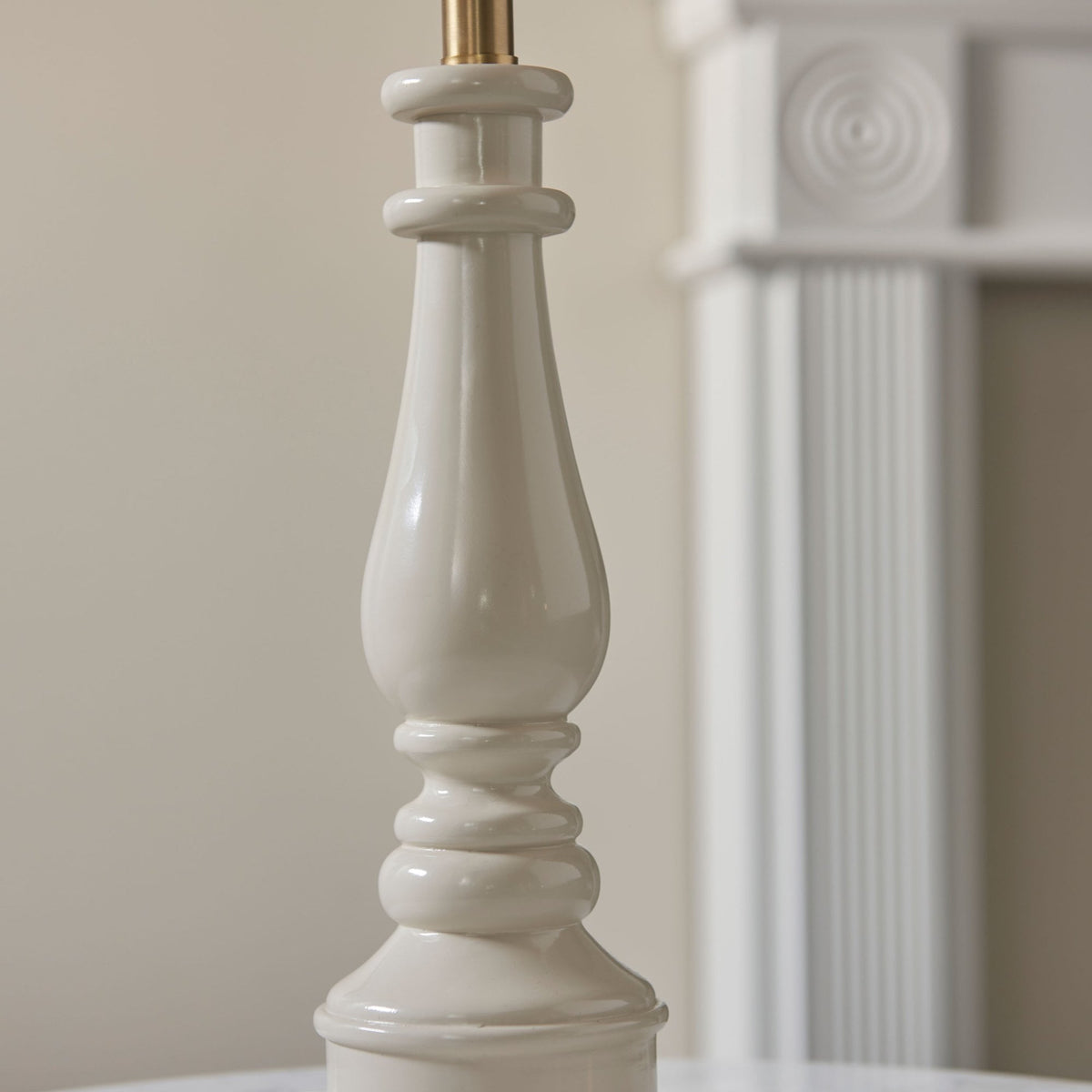 Close-up of the cream-coloured fluted base of a table lamp.
