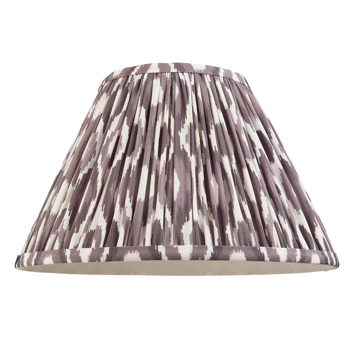 A dark ikat patterned pleated lampshade with a white lining, on a white background.