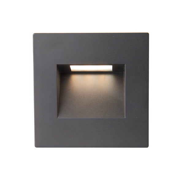 A black square recessed wall light with warm light.